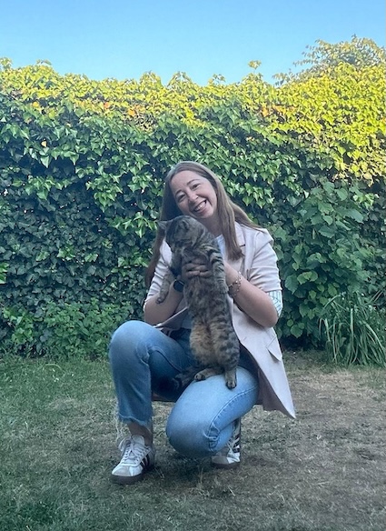 Miray Koral lacht in de tuin met haar kat in de armen