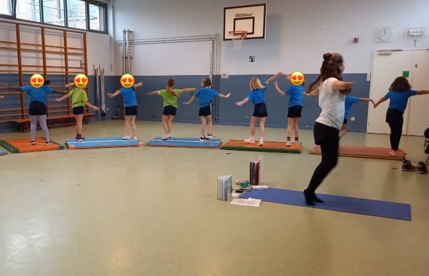 Miray Koral geeft een yogales aan een groep kinderen in een turnzaal